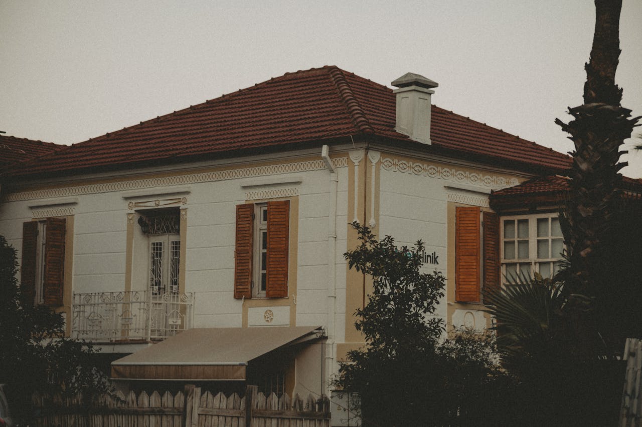 A house with orange shutters and a palm tree